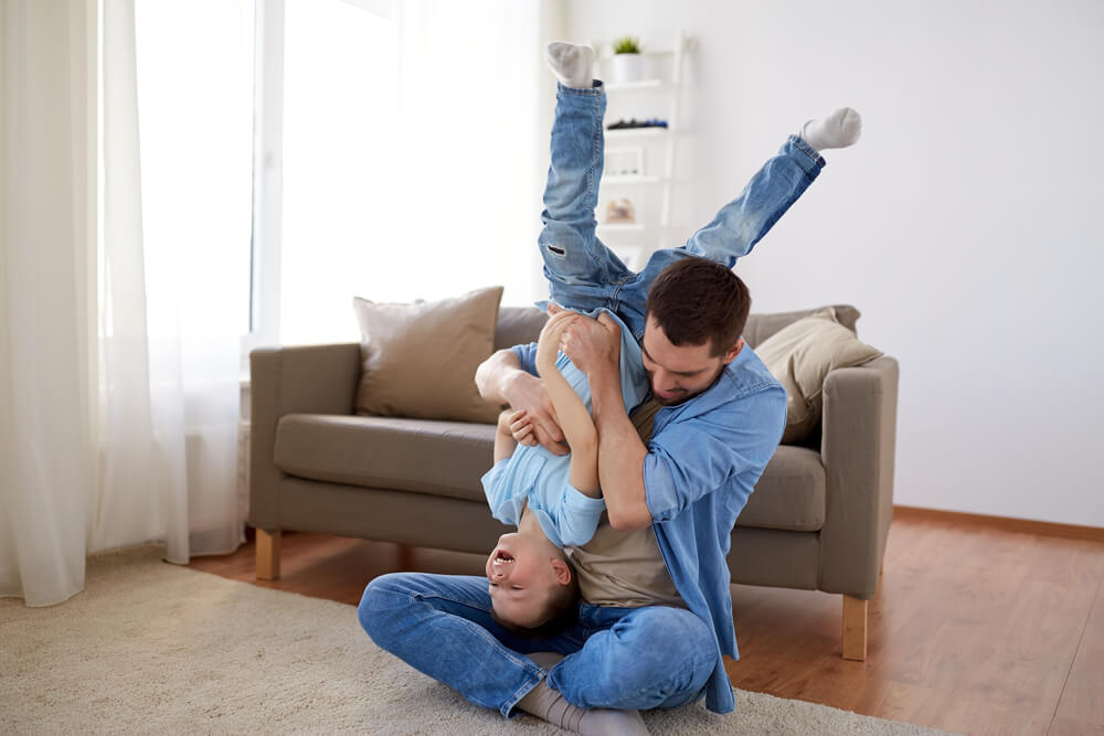 Vater spielt mit Sohn im Wohnzimmer