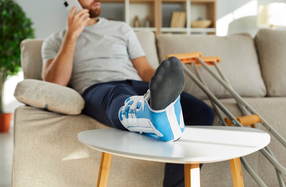 mann mit gebrochenem bein telefoniert