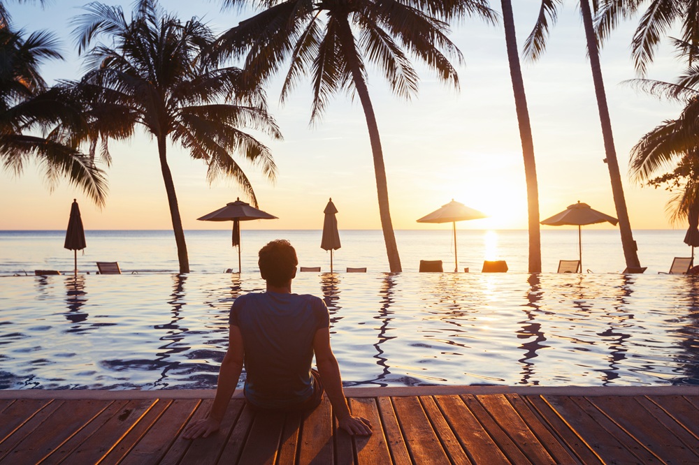 Mann in der Karibik am Meer beim Sonnenuntergang