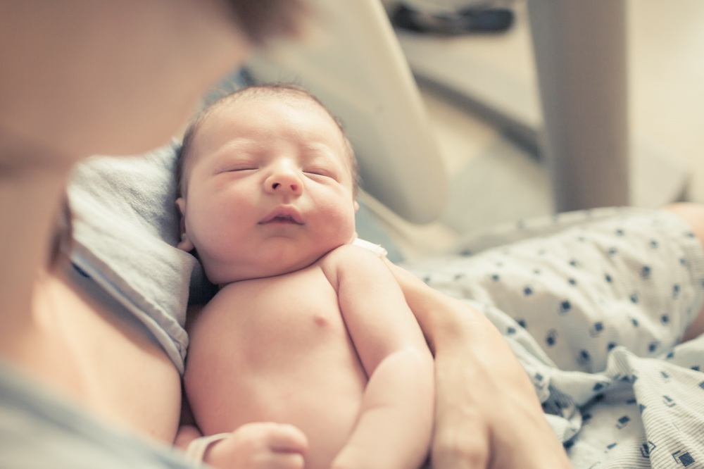 Neugeborenes im Arm der Mutter