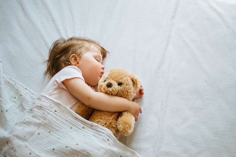 Baby schläft mit Teddybär