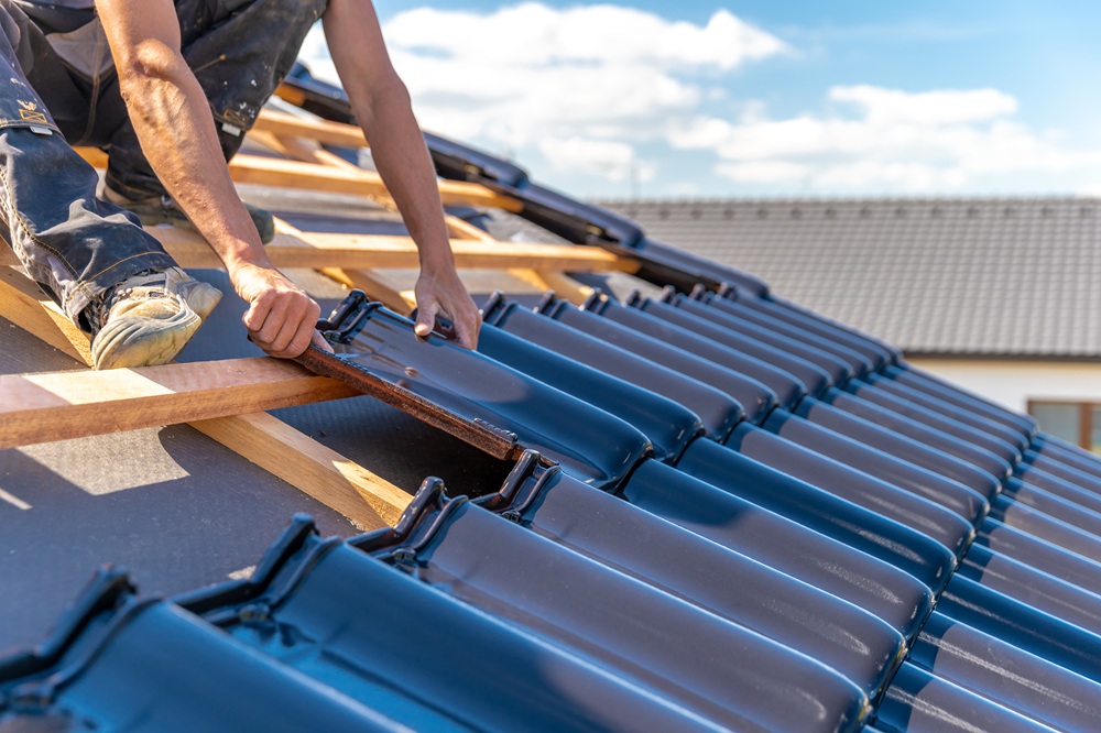Dachdecker setzt neue Platten ein
